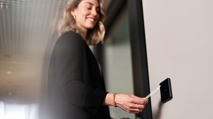 Une femme ouvre la porte avec une carte au terminal d'accès IF-800